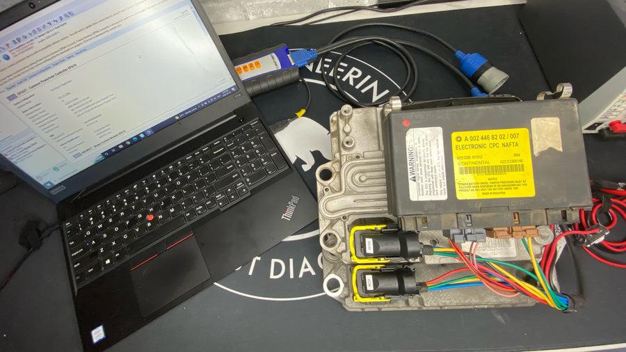 Diesel engine ECM reflashing process using a diagnostic programming interface and laptop.
